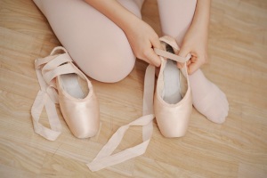 Girl putting on pointe shoes
